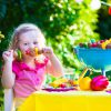 Kinderen Die Vlees Grillen. Familie Het Kamperen En Het Genieten Van BBQ. Klein Meisje Bij Barbecue Die Steaks, Kebab En Maïs Voorbereidt. Kinderen Die Grill En Gezonde Plantaardige Maaltijd Buiten Eten. Tuinpartij Voor Peuterkind