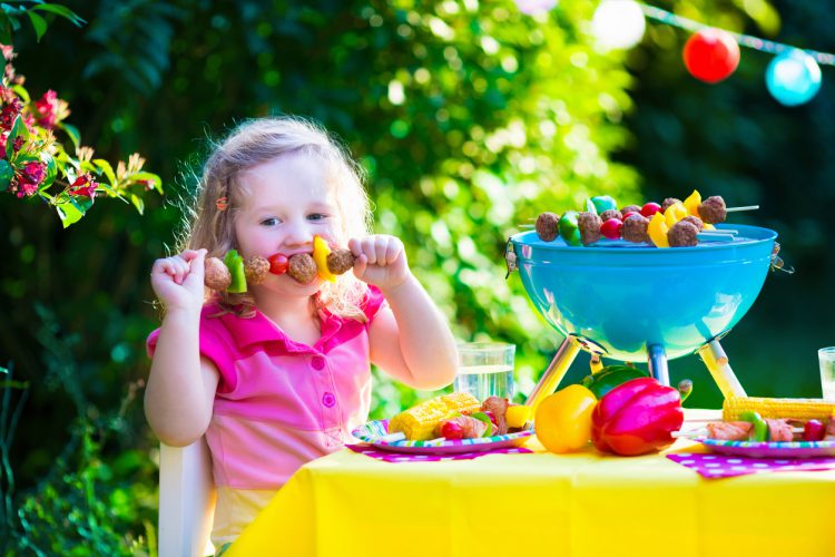 Kinderen die vlees grillen. Familie het kamperen en het genieten van BBQ. Klein meisje bij barbecue die steaks, kebab en maïs voorbereidt. Kinderen die grill en gezonde plantaardige maaltijd buiten eten. Tuinpartij voor peuterkind