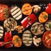 Achtergrond van gegrilde tomaten, paprika's en champignons als close-up. Horizontaal bovenaanzicht.
