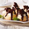 Heerlijke eclairs met room en chocolade glazuur op een bord. Foto horizontaal gefotografeerd.
