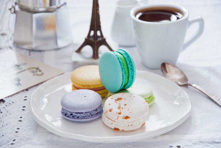 Ontbijt met Franse kleurrijke macarons en een koffiezetapparaat met koffiekopje