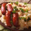 Stamppot aardappelpuree, kool en wortelen, met gekruide worstjes.