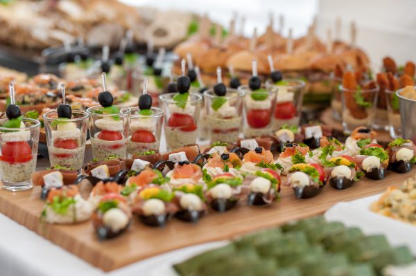 Verjaardagstafel met eten. Kleine hapjes en voorgerecht op de tafel. Vis en rauw vlees met groenten.